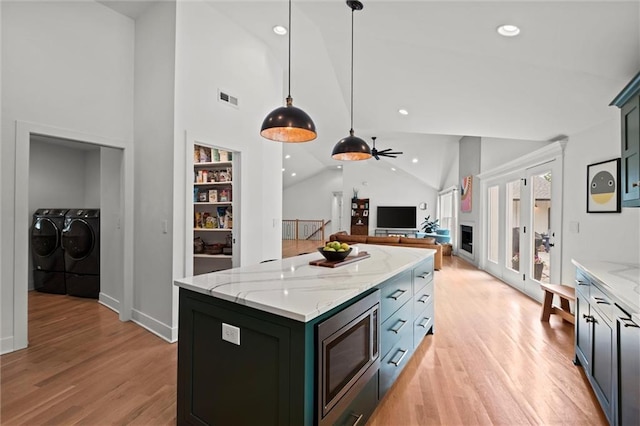9818 Overbrook Ct, Leawood, KS 66206 - kitchen with separate washer and dryer, high vaulted ceiling, stainless steel microwave, light wood-type flooring, and visible vents