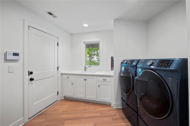 9818 Overbrook Ct, Leawood, KS 66206 - washroom with visible vents, washer and clothes dryer, light wood finished floors, and a sink