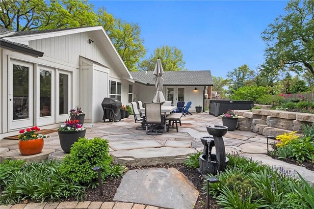 9818 Overbrook Ct, Leawood, KS 66206 - back of property featuring french doors, outdoor dining area, roof with shingles, a patio area, and a hot tub