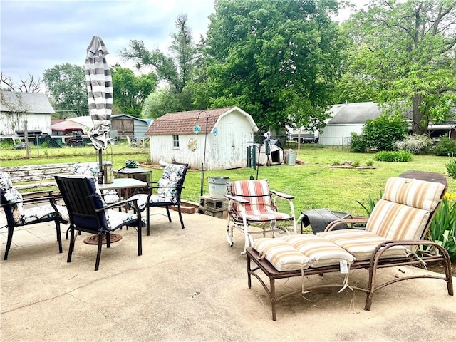 view of patio / terrace with fence, an outdoor structure, outdoor dining area, and a shed