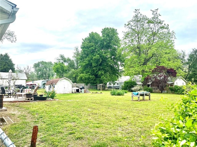 view of yard featuring an outdoor structure, fence, and a shed
