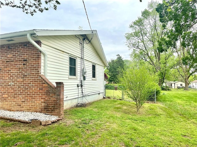 view of side of property featuring a yard and fence