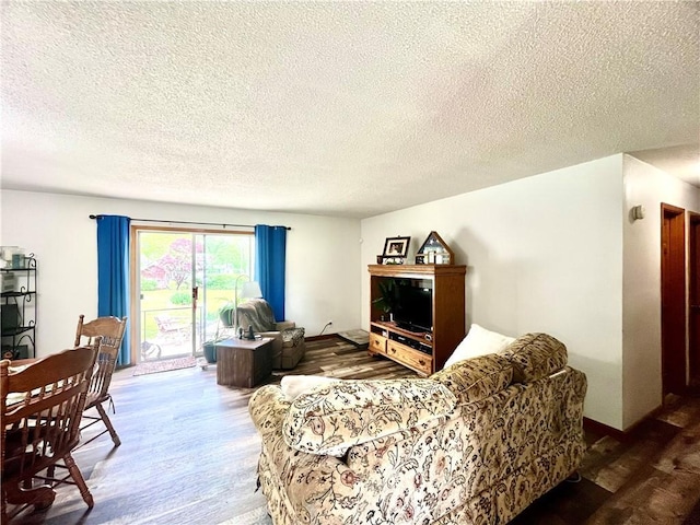 living area with a textured ceiling and wood finished floors