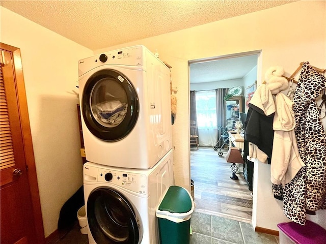 laundry area featuring stacked washer and dryer, laundry area, and a textured ceiling