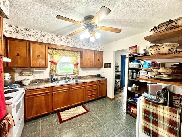 kitchen featuring a sink, brown cabinetry, a ceiling fan, and electric range
