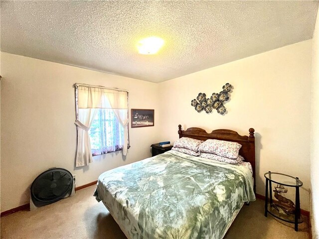 carpeted bedroom featuring baseboards and a textured ceiling