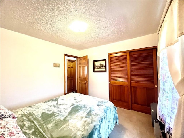 bedroom with a textured ceiling, light carpet, and a closet