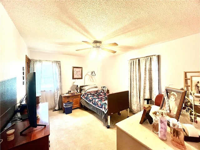 bedroom with light carpet, a ceiling fan, and a textured ceiling