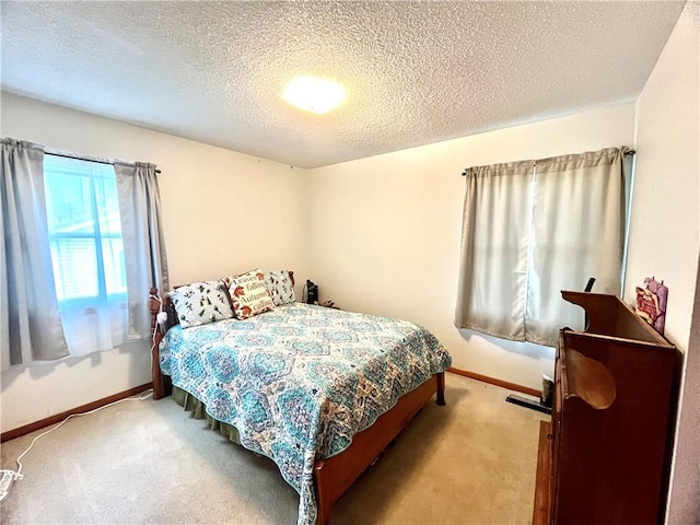 carpeted bedroom with a textured ceiling and baseboards