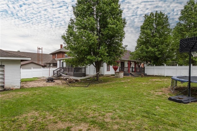 516 Parker St, Osawatomie, KS 66064 - view of yard with a trampoline, a fire pit, and a wooden deck