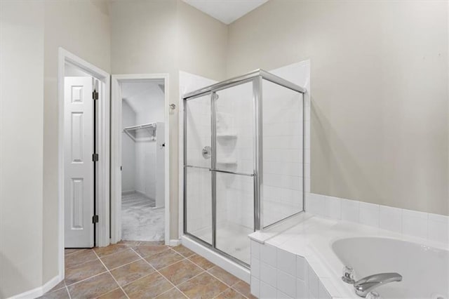 14175 W 149th Ter, Olathe, KS 66062 - bathroom featuring a bath, a shower stall, a spacious closet, and tile patterned floors