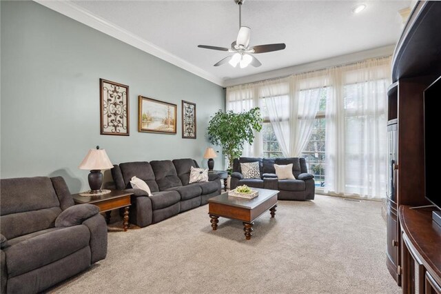 carpeted living room with a ceiling fan and ornamental molding
