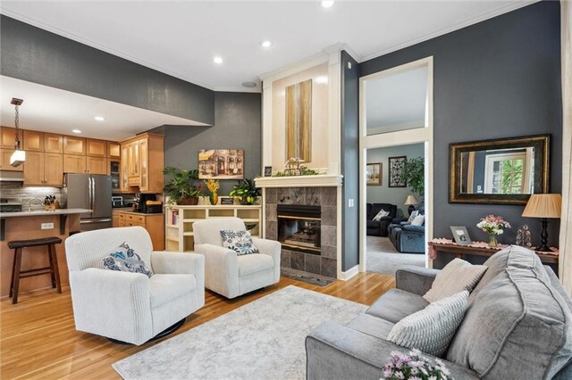 living room featuring light wood-style floors, ornamental molding, and recessed lighting