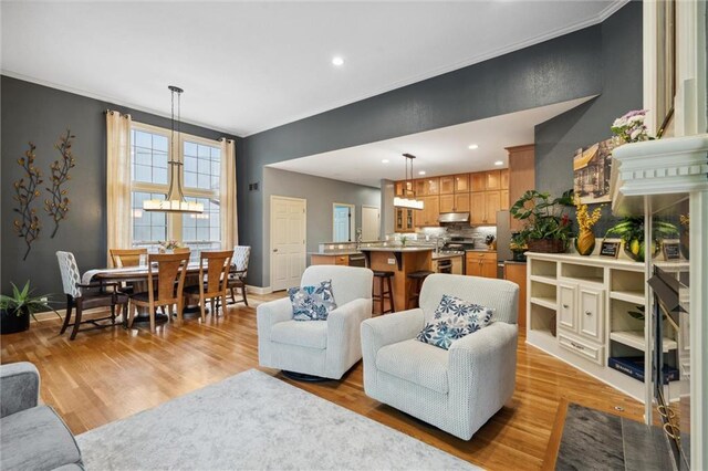 living area with crown molding, recessed lighting, and an inviting chandelier