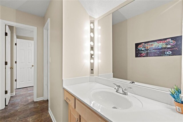 bathroom with baseboards, vanity, and stone finish flooring