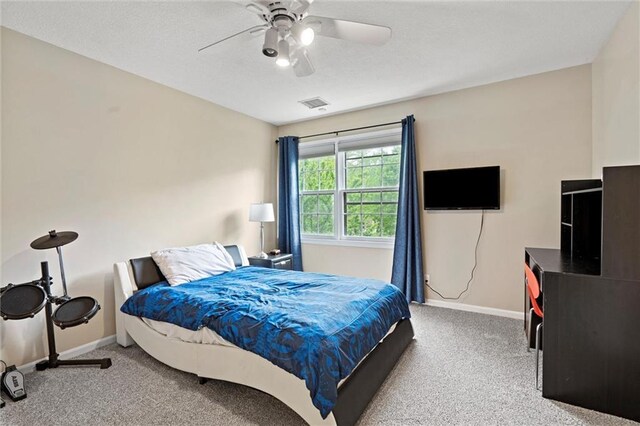 carpeted bedroom featuring baseboards, ceiling fan, and visible vents