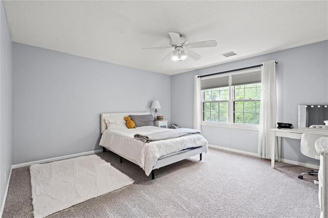 bedroom with visible vents, a ceiling fan, baseboards, and carpet floors