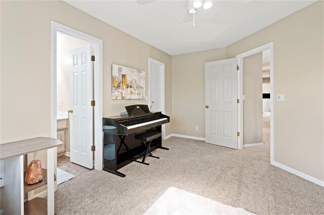 sitting room featuring baseboards, ceiling fan, and carpet flooring