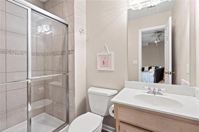 ensuite bathroom with vanity, a stall shower, toilet, and connected bathroom