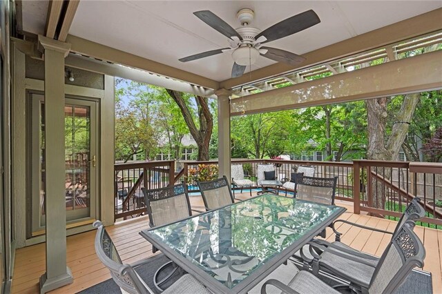 wooden terrace with ceiling fan and outdoor dining area