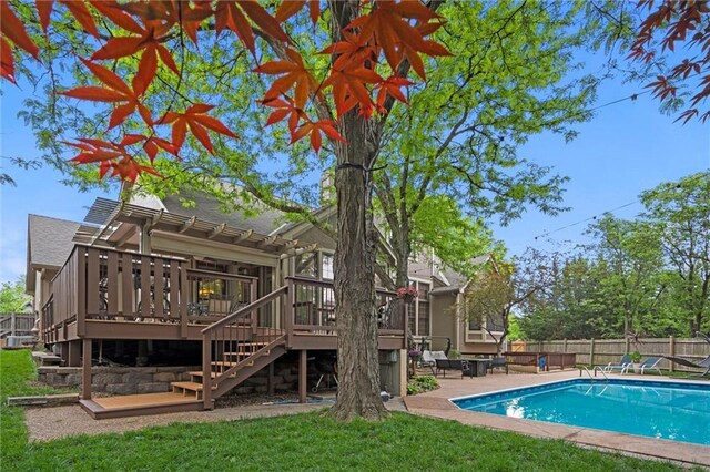 view of pool with fence, stairs, a deck, a fenced in pool, and a lawn