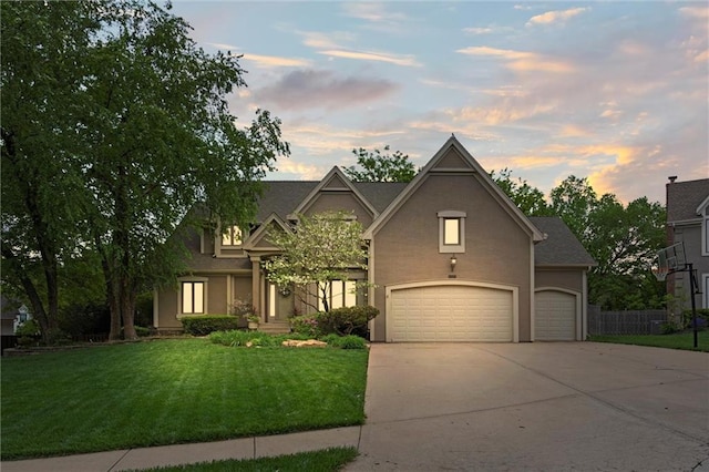 view of front of house with concrete driveway, a garage, a front yard, and stucco siding