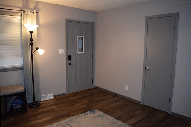 foyer entrance with visible vents, wood finished floors, and baseboards