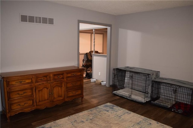 bedroom with dark wood finished floors and visible vents