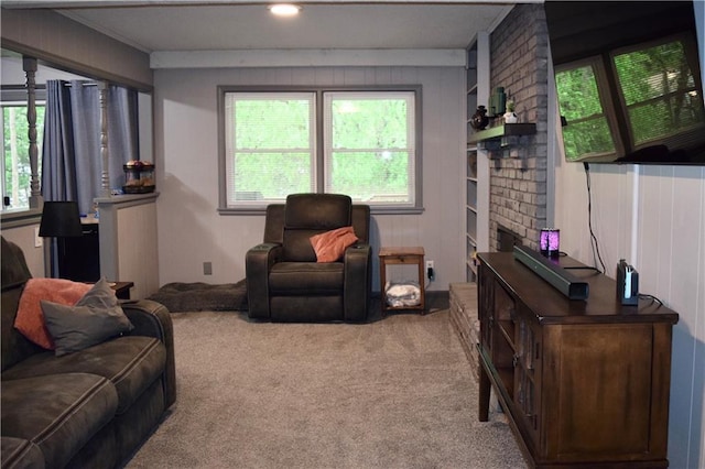 carpeted living area with wood walls and a fireplace