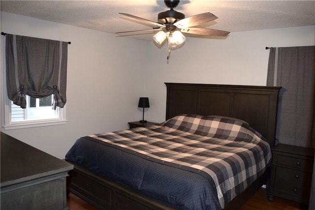 bedroom featuring a ceiling fan, a textured ceiling, and dark wood-style flooring