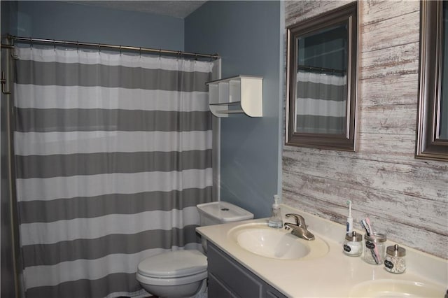 bathroom with a shower with shower curtain, toilet, double vanity, and a sink