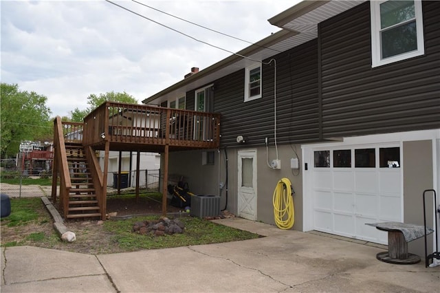 back of property featuring a wooden deck, stairway, a garage, central AC, and fence