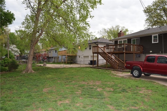 view of yard with a deck, stairs, and fence