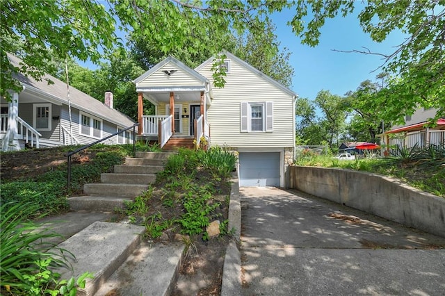 758 Pennsylvania St, Leavenworth, KS 66048 - view of front of house featuring a porch, concrete driveway, stairway, and an attached garage