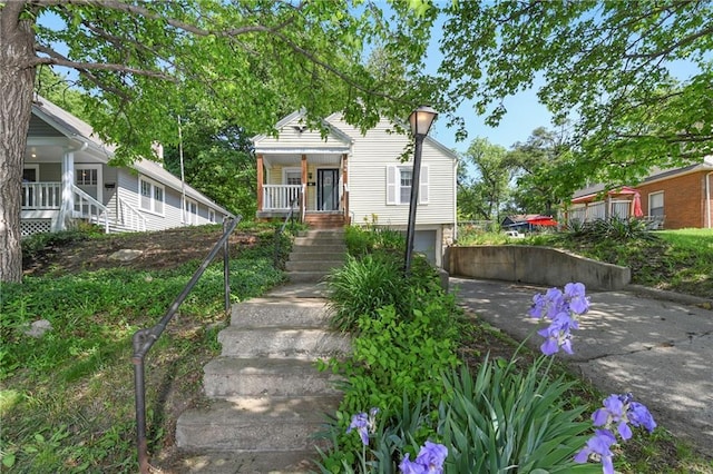 758 Pennsylvania St, Leavenworth, KS 66048 - bungalow-style home with asphalt driveway, stairs, an attached garage, and a porch