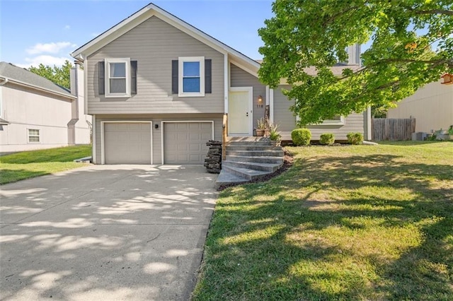 bi-level home featuring fence, concrete driveway, a front lawn, and a garage