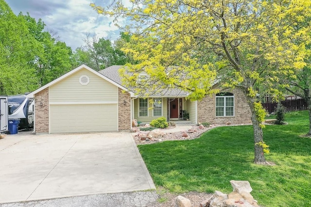 view of front of house featuring fence, a front yard, brick siding, an attached garage, and driveway