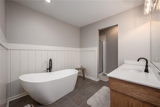 bathroom featuring a freestanding bath, wainscoting, vanity, tile patterned floors, and a shower stall