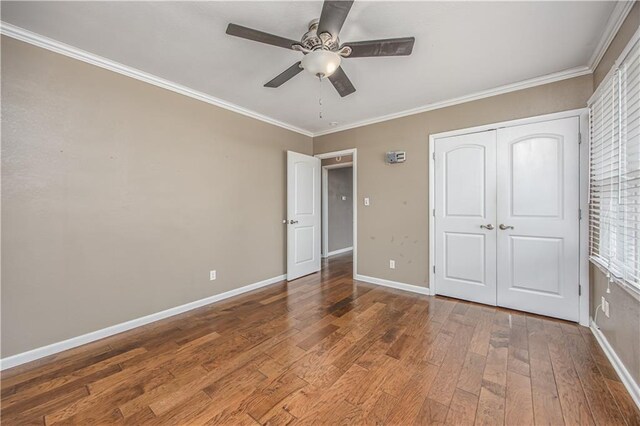 306 S 5th St, Neodesha, KS 66757 - unfurnished bedroom featuring hardwood / wood-style flooring, crown molding, a closet, baseboards, and a ceiling fan