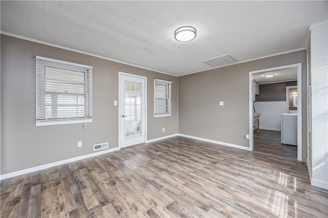 306 S 5th St, Neodesha, KS 66757 - unfurnished living room with wood finished floors, visible vents, crown molding, and baseboards