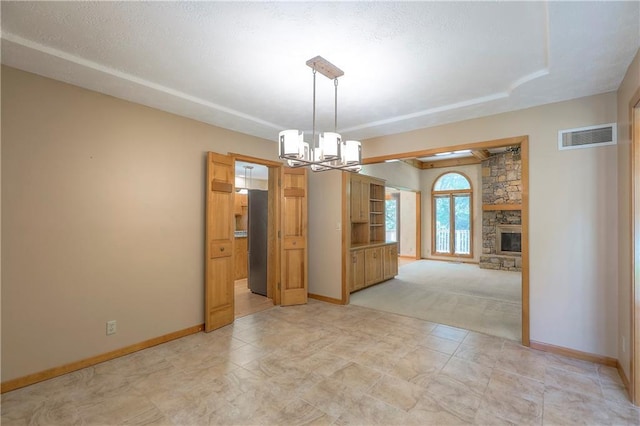 12341 Beverly St, Leawood, KS 66209 - spare room featuring a chandelier, a fireplace, baseboards, and light colored carpet