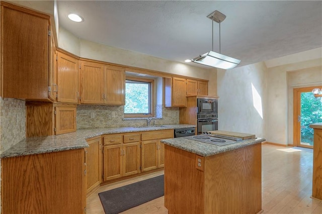 12341 Beverly St, Leawood, KS 66209 - kitchen with black appliances, a sink, decorative backsplash, light wood-style floors, and a kitchen island