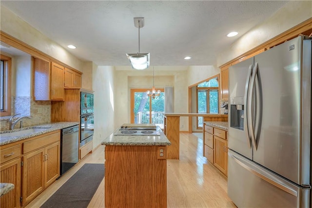 12341 Beverly St, Leawood, KS 66209 - kitchen with black appliances, a sink, a kitchen island, decorative backsplash, and light wood finished floors