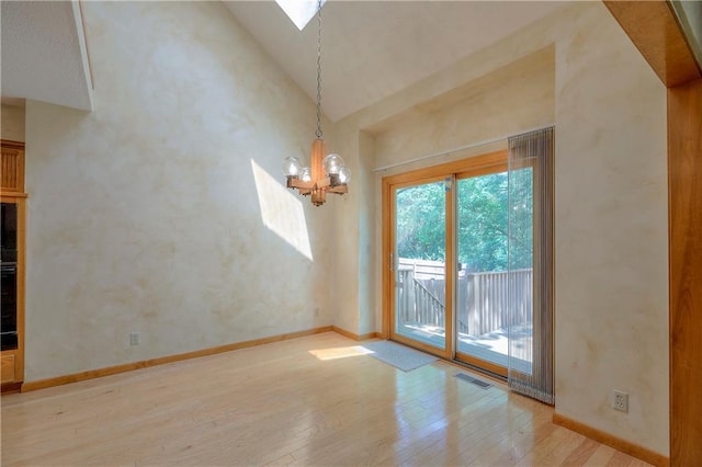 12341 Beverly St, Leawood, KS 66209 - unfurnished room with hardwood / wood-style floors, a chandelier, baseboards, a skylight, and high vaulted ceiling