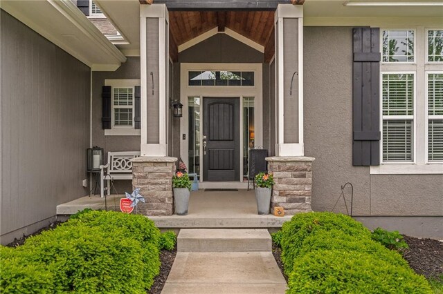 doorway to property featuring a porch and stucco siding