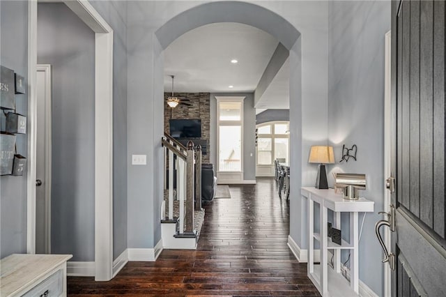foyer featuring baseboards, arched walkways, ceiling fan, and hardwood / wood-style floors