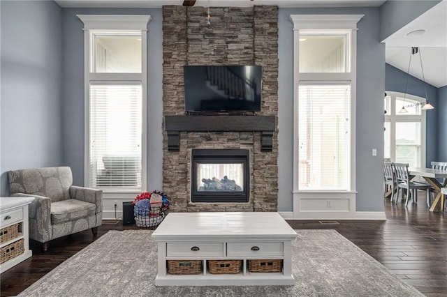living room featuring a fireplace, baseboards, ceiling fan, dark wood finished floors, and vaulted ceiling