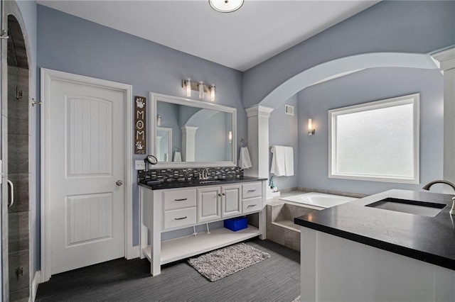 bathroom featuring vanity, visible vents, a bath, tasteful backsplash, and a shower stall