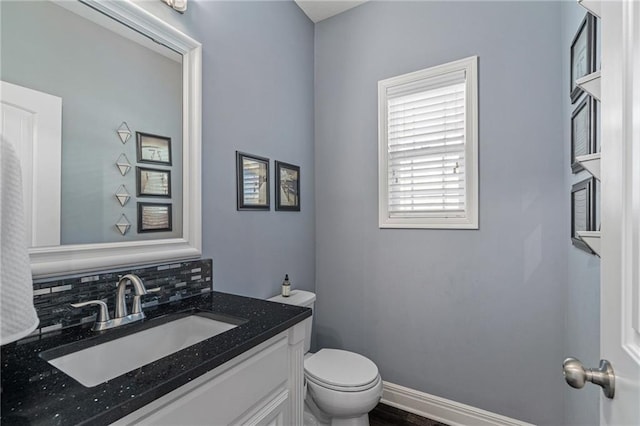 bathroom featuring toilet, tasteful backsplash, and vanity