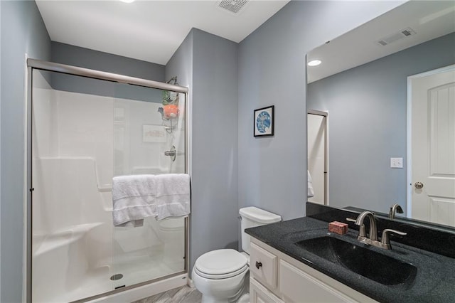 full bathroom with vanity, toilet, visible vents, and a stall shower